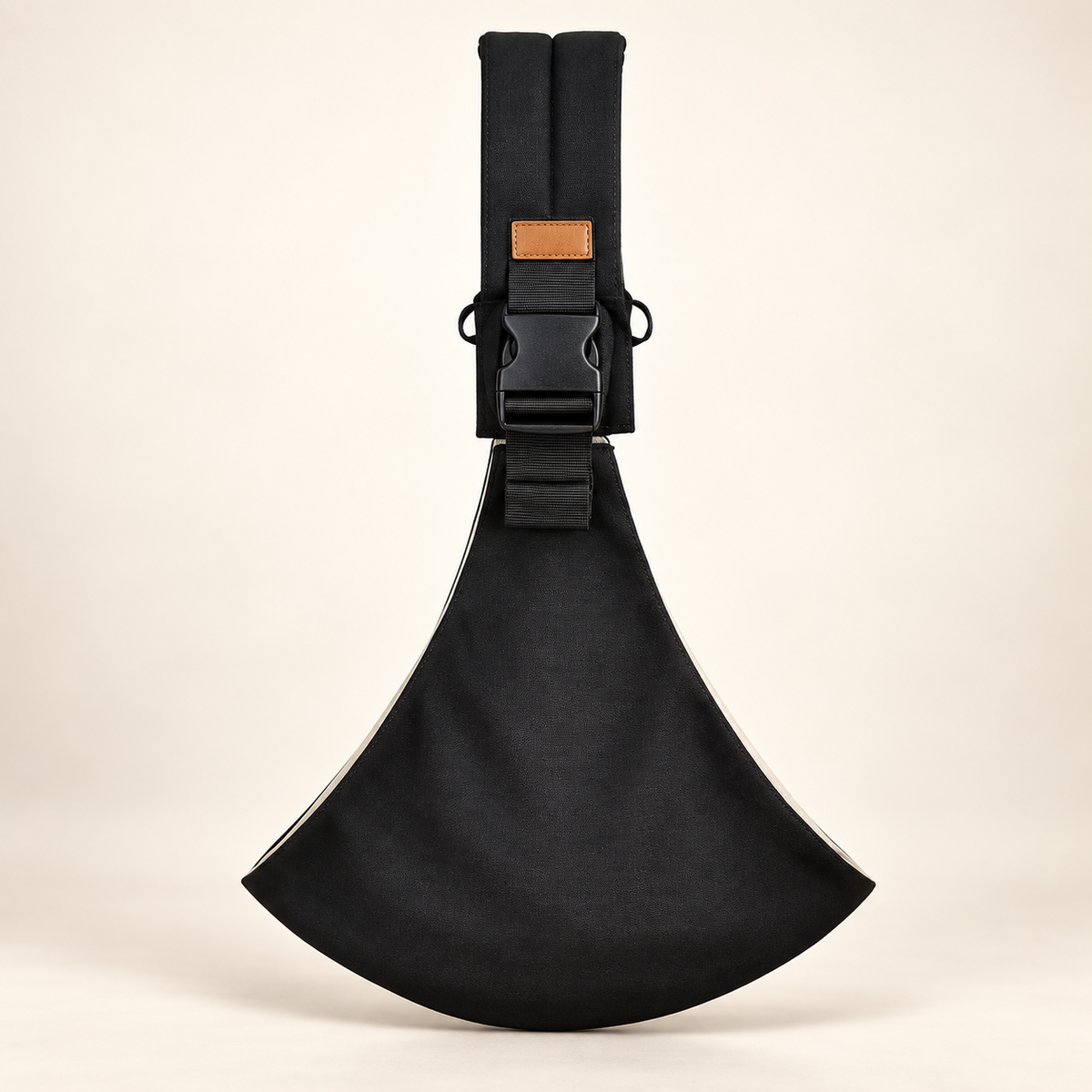 Black Baby Sling Carrier with adjustable shoulder strap and black buckle on ivory backdrop