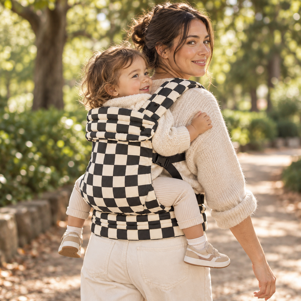 Mother using the Née Checkerboard carrier in a back carry position