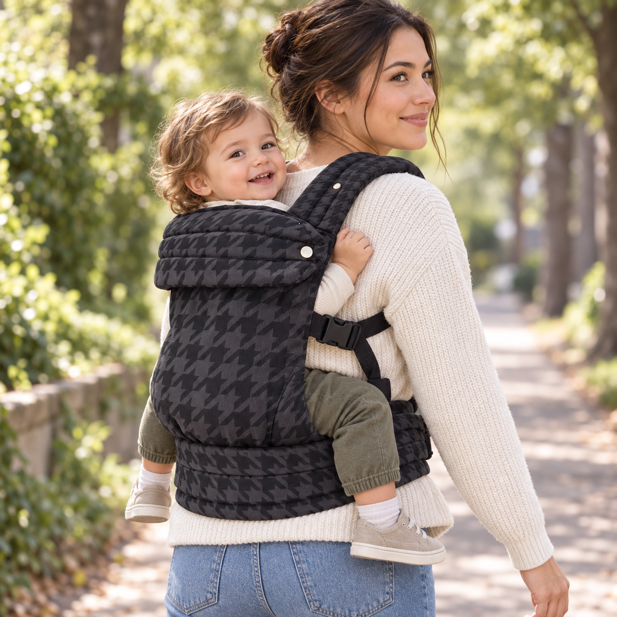 Mother wearing the Denim Check ergonomic baby carrier in a back carry