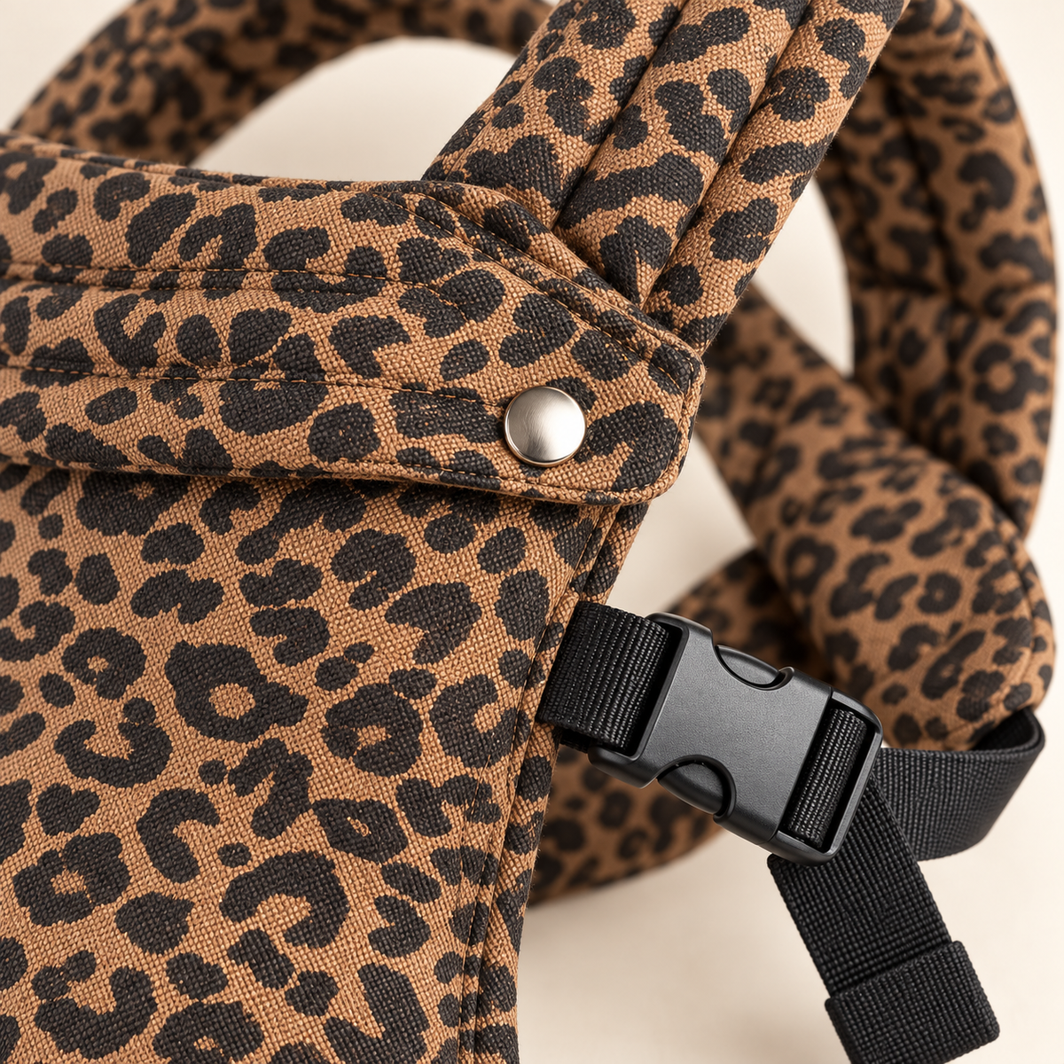 Leopard Print baby carrier fabric, snap, buckle, and stitching detail