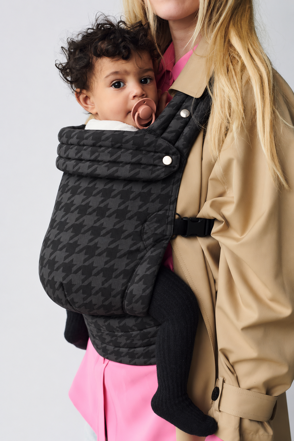 Close-up of baby in the Née Denim Check ergonomic baby carrier, showing its woven pattern