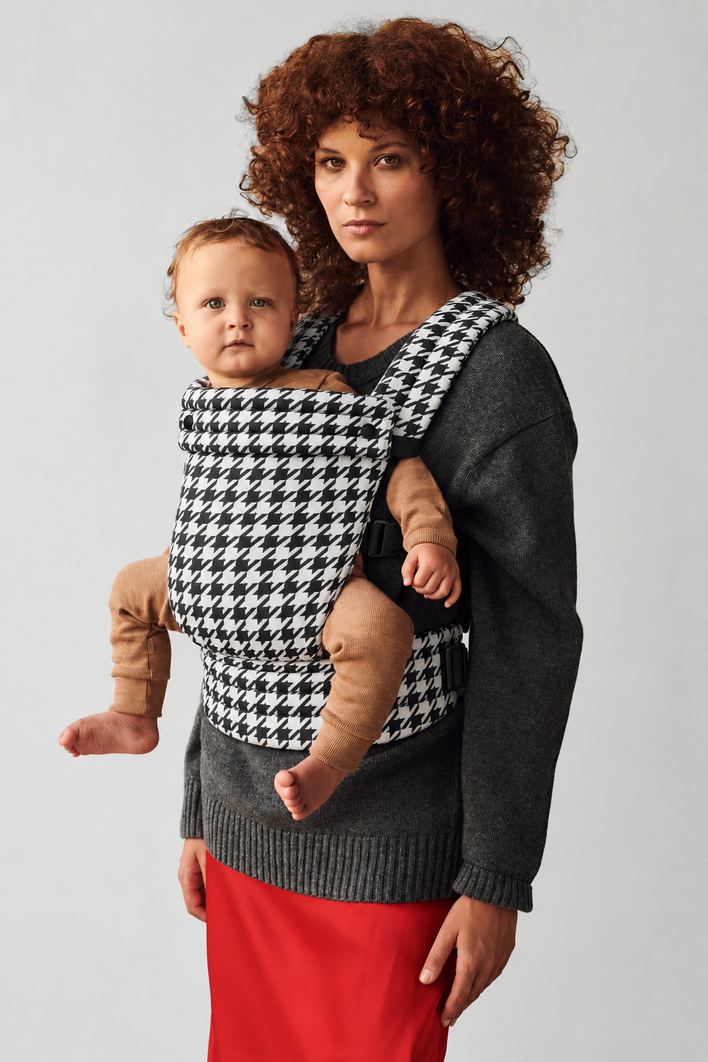 Mother and baby in a front carry in the Née Grand Houndstooth ergonomic baby carrier