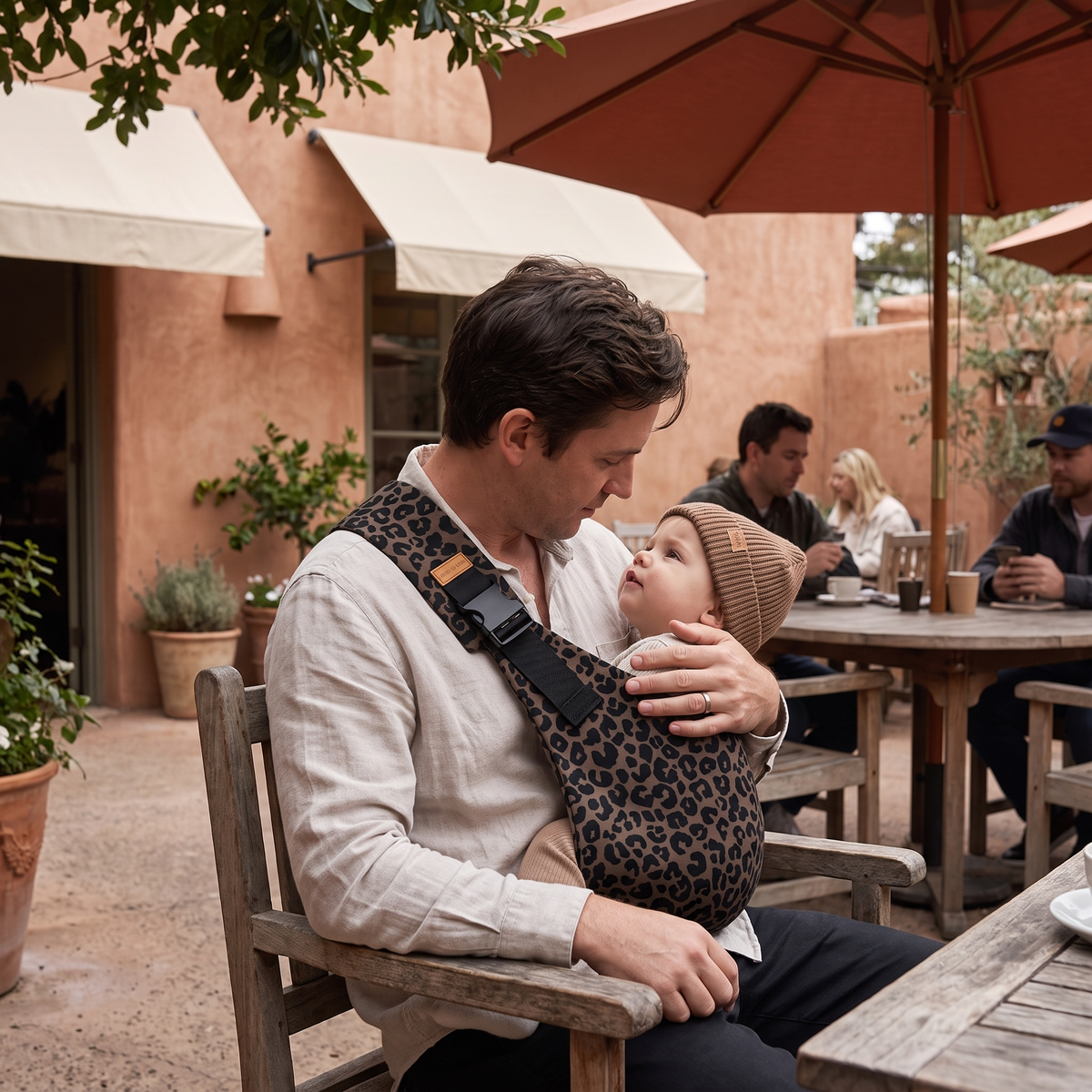 Dark Leopard Print Baby Sling Carrier at an everyday café outing