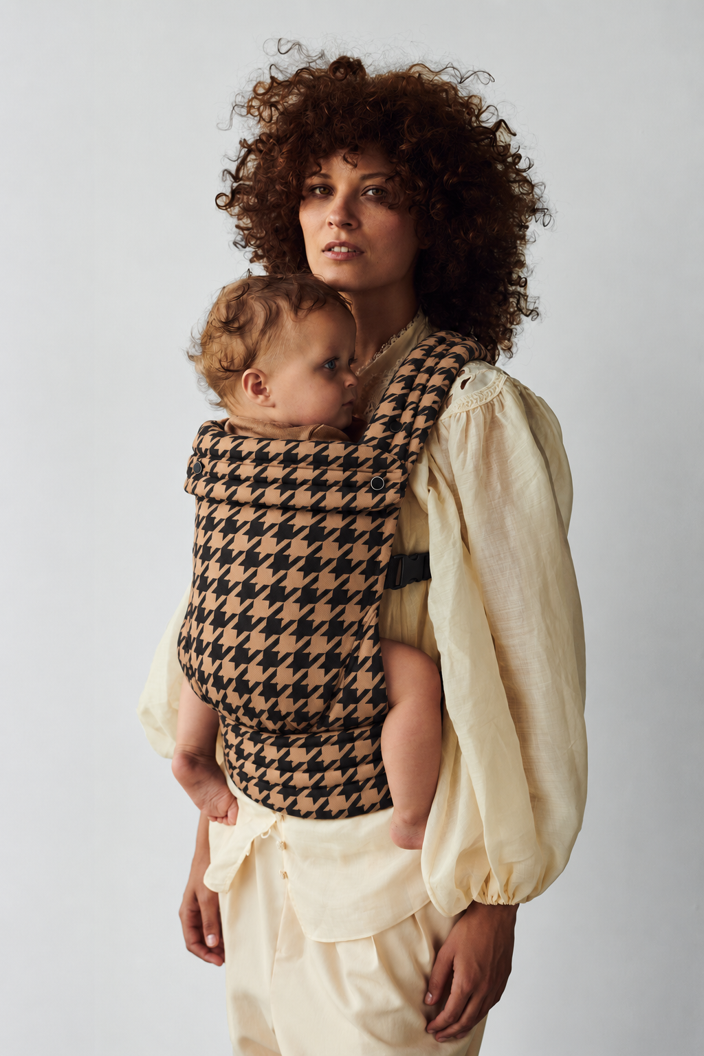 Closer portrait of mother and baby in the Née Noir Houndstooth ergonomic baby carrier