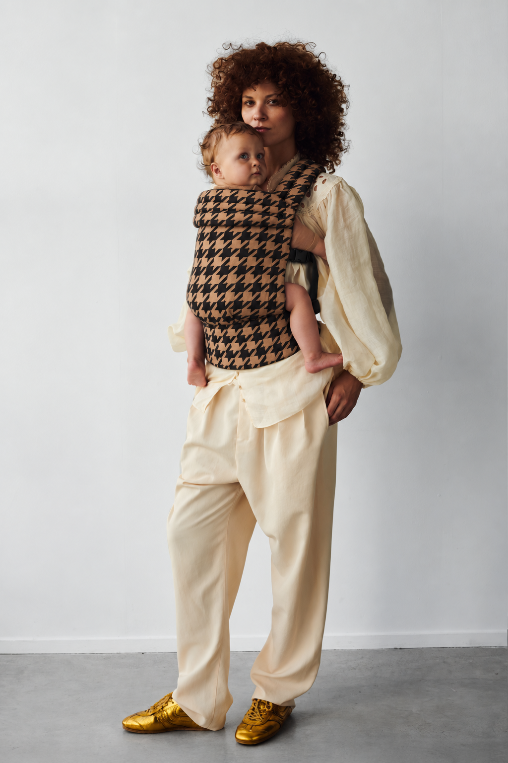 Mother and baby in a front carry in the Née Noir Houndstooth ergonomic baby carrier