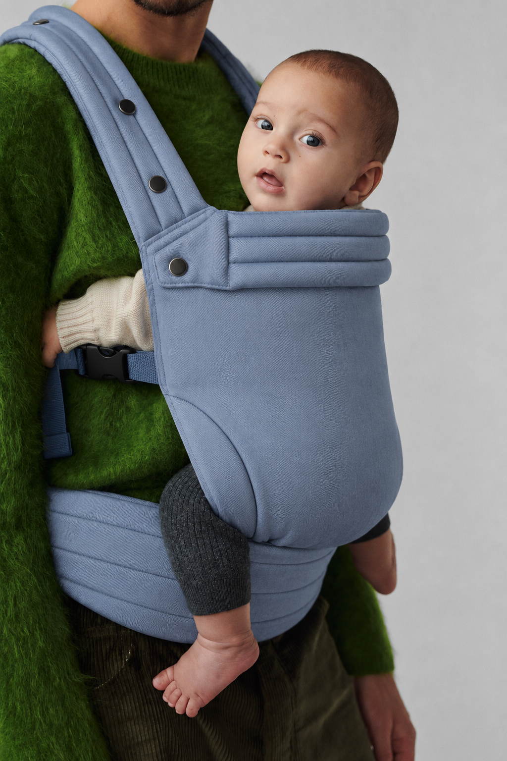 Close-up of a father carrying baby in the Née Powder Blue ergonomic baby carrier