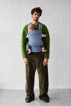 Father wearing the Née Powder Blue ergonomic baby carrier with baby, full-length front view
