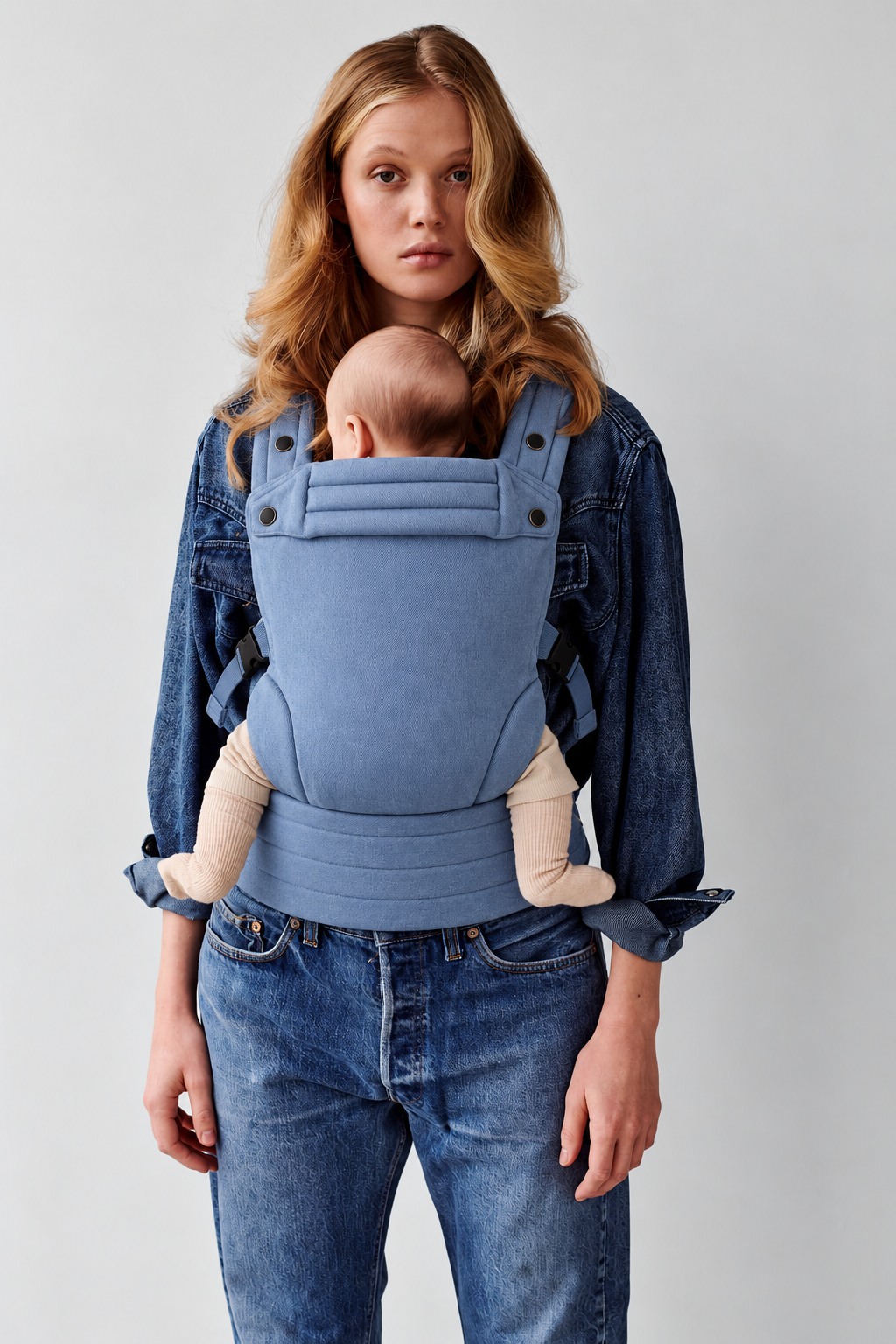 Closer front view of a mother and baby in the Née Powder Blue ergonomic baby carrier
