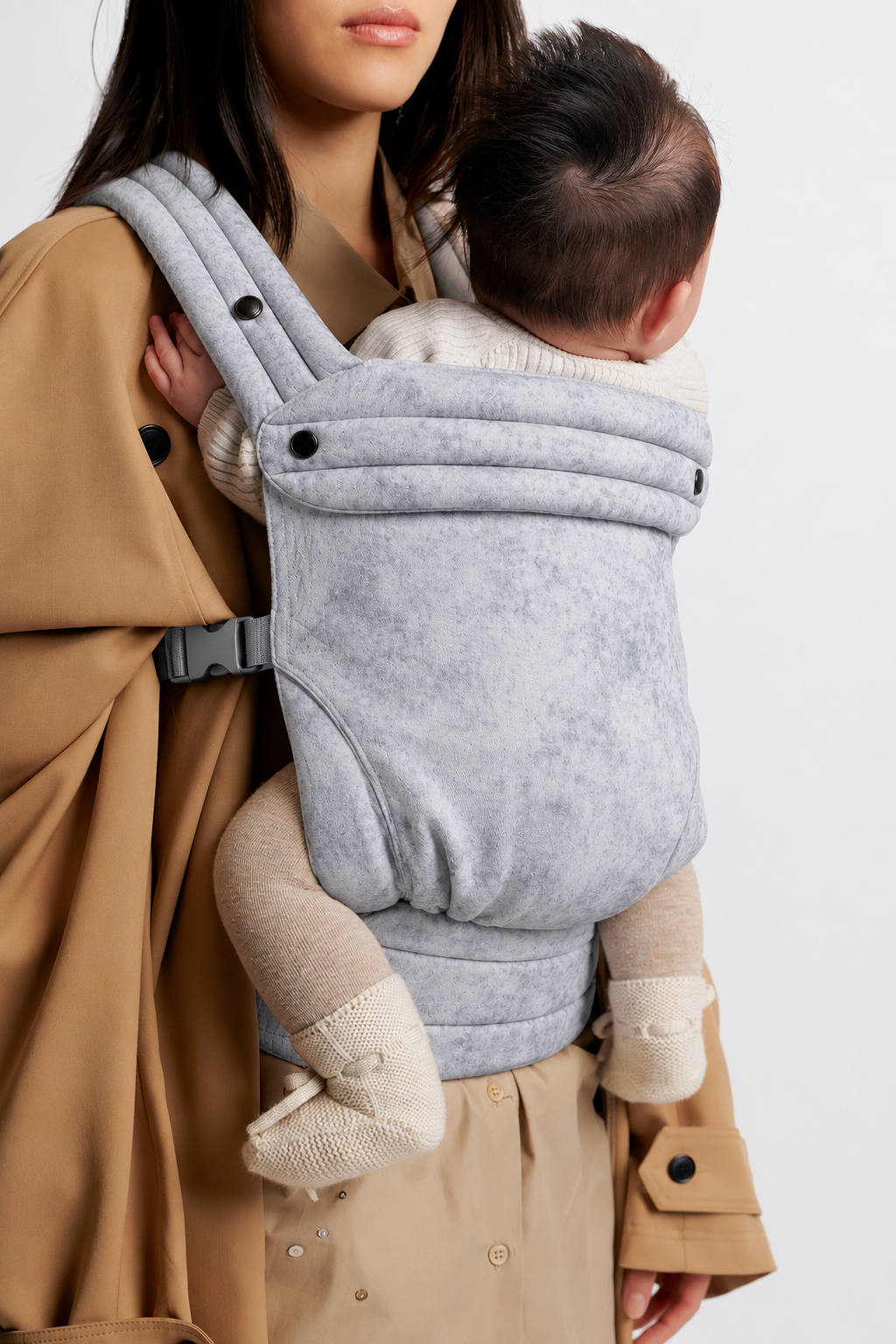 Close-up of baby in the Née Silver Mist Grey ergonomic baby carrier, showing the patterned fabric panel