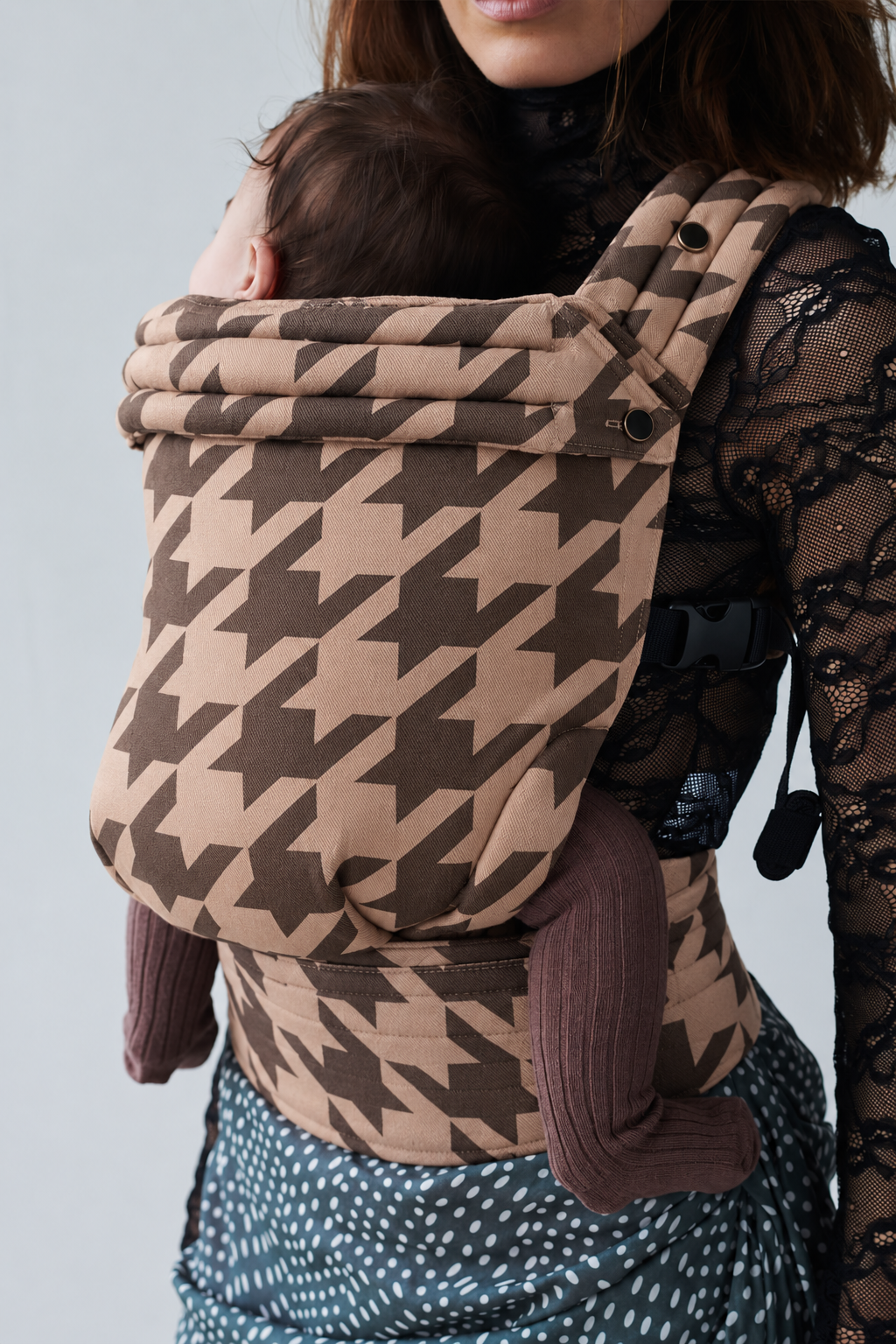 Close-up of baby in the Née Stone Houndstooth Grey ergonomic baby carrier, showing its woven pattern